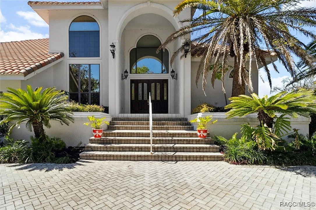 Grand arched front entrance with palms